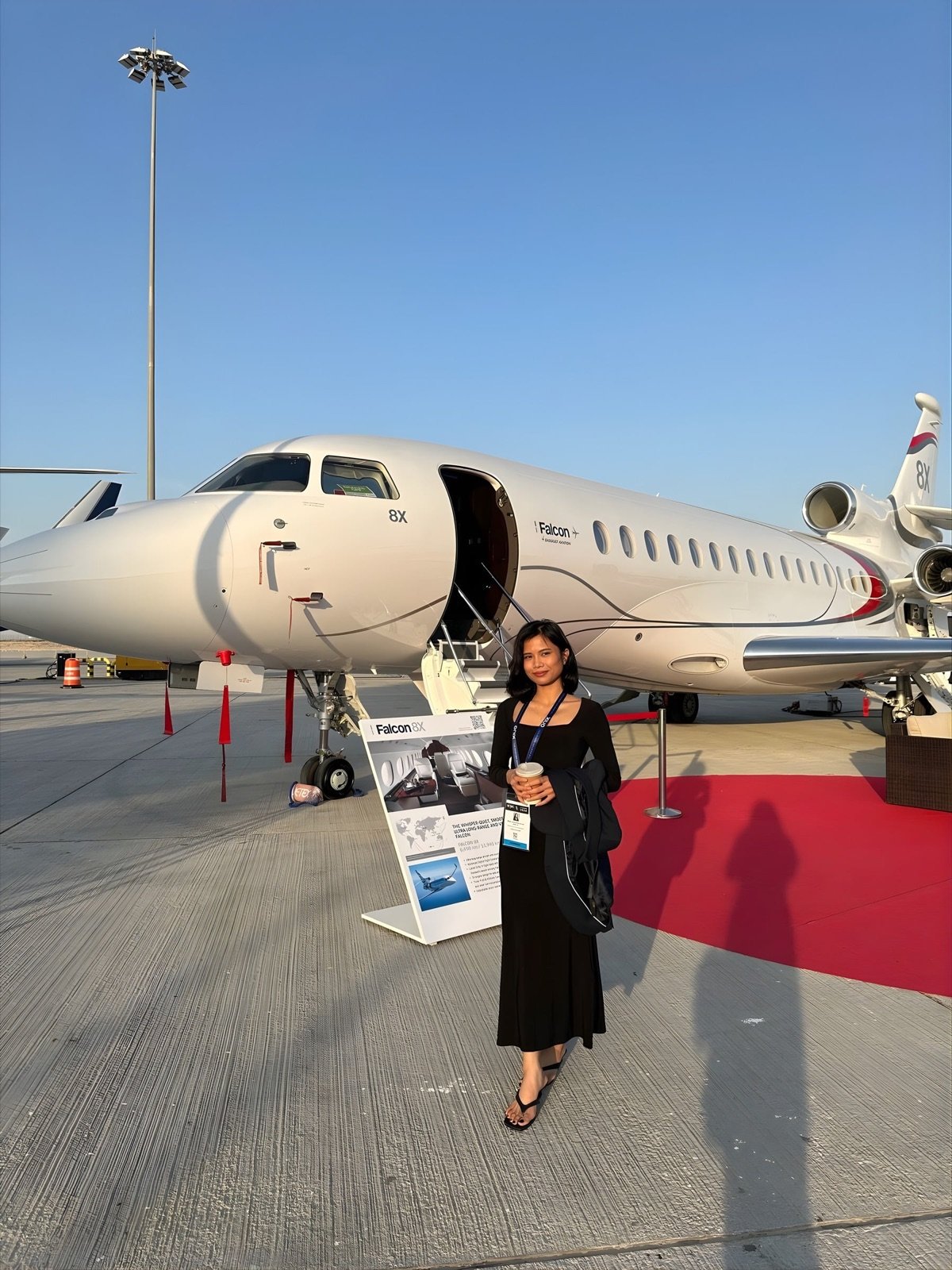 Catherine Delos Santos beside a Falcon business jet at an air show